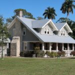 brown and white concrete house near green grass field during daytime