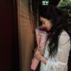 woman holding rose bouquet facing door