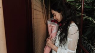 woman holding rose bouquet facing door