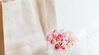 pink rose bouquet beside brown paper bag