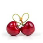 two red cherry fruits on white surface