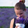 woman smelling bouquet of purple lavender