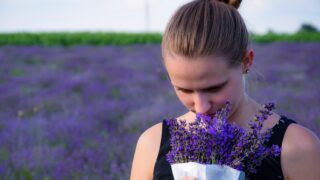 woman smelling bouquet of purple lavender