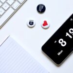 a white desk with a keyboard, phone, and magnets