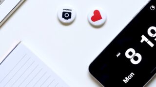 a white desk with a keyboard, phone, and magnets