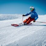 man ice skiing on hill