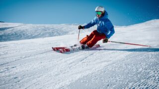 man ice skiing on hill