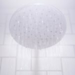 water from round gray stainless steel shower head