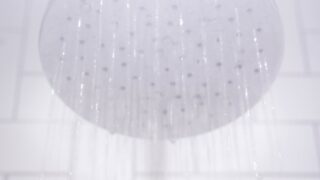 water from round gray stainless steel shower head