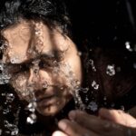 woman in black shirt with water droplets