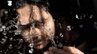 woman in black shirt with water droplets