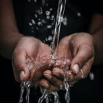 pouring water on person's hands