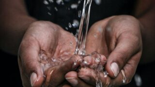 pouring water on person's hands