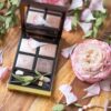 makeup palette beside pink flowers