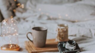 black and gray camera beside gray mug