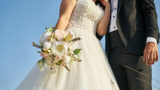 woman in white wedding dress holding bouquet of white flowers